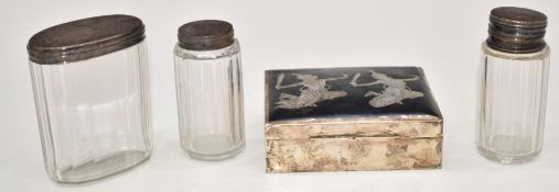 Three hallmarked silver mounted glass dressing table bottles and a Thai silver cigarette box