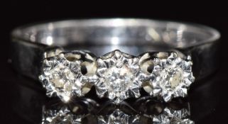 A 9ct white gold ring set with three diamonds in an illusion setting, 3.3g, size N