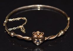 Victorian 9ct gold bangle set with a sapphire and seed pearls in a heart setting, 4.7g