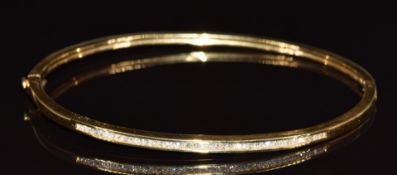 An 18ct gold bangle set with 40 princess cut diamonds the total diamond weight approximately 0.