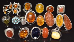 Nineteen silver rings set with amber, faux sunstone, etc