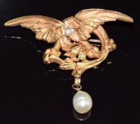A 19thC yellow metal pendant/ brooch in the form of a phoenix set with two pearls and a drop pearl