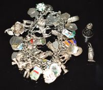 A silver charm bracelet with charms including enamel shields, a flower opening to reveal a bee, cat,