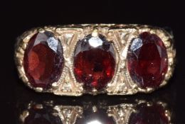 A 9ct gold ring set with three oval cut garnets, 3.7g, size O