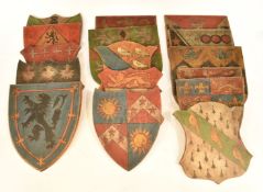 Sixteen hand decorated armorial or heraldic panels, each shield shaped and depicting a coat or