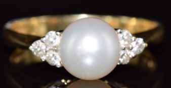 An 18k gold ring set with a pearl and diamonds, 3.3g, size N
