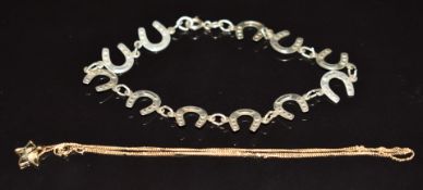 A 9ct gold chain and pendant (0.7g) and a silver horseshoe bracelet