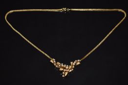 An 18ct gold necklace set with diamonds in a heart and scrolling design, 13.8g, 43cm long
