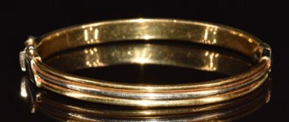A bi-coloured 18ct gold bangle, 21.4g, 6.2 x 4.9cm