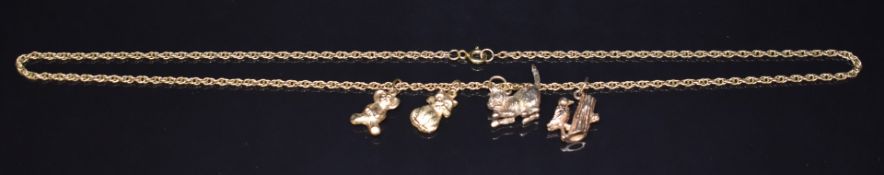 A 9ct gold chain and four 9ct gold charms in the form of a woodpecker, teddy bear, and two cats,
