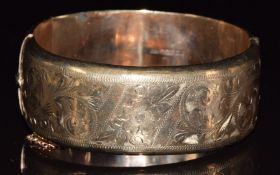 A 9ct gold bangle with engraved foliate decoration, in vintage box, 28.9g, 6 x 5.5cm