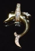 A 14k gold pendant in the form of a dolphin set with cubic zirconia, 7.9g
