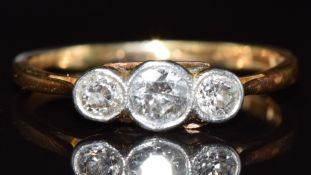 An 18ct gold ring set with three diamonds in a platinum setting, the largest approximately 0.18ct,