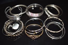 Thirteen silver bangles including Victorian Etruscan Revival, topaz, etc