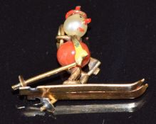 A 9ct gold charm in the form of a skier made up of a pearl and a coral bead, 1.5g