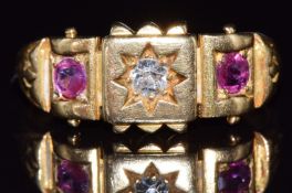 Late Victorian/ early Edwardian 18ct gold ring set with a diamond and two rubies in star settings,