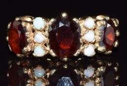A 9ct gold ring set with garnets and opals, 3.4g, size P