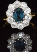 An 18ct gold ring set with an oval cut sapphire surrounded by diamonds, each approximately 0.1ct,