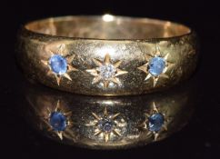 An 18ct gold ring set with a diamond and sapphires in star settings, Chester 1912, 2.1g, size P