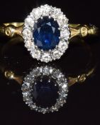An 18ct gold ring set with an oval cut sapphire of approximately 0.75ct surrounded by diamonds,