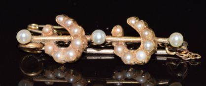 Edwardian yellow metal brooch in the form of two horseshoes set with pearls and split pearls, 5.1g