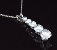 A 10k white gold pendant set with four graduated aquamarines, 45cm long, 1g
