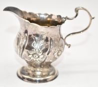 Georgian hallmarked silver jug with embossed decoration, marks indistinct but likely London 1765,