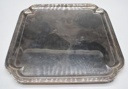 Elizabeth II hallmarked silver salver of square form with ornate corners, raised on four feet,