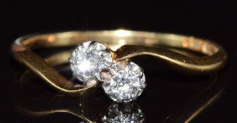 An 18ct gold ring set with two diamonds in a twist setting, 2.1g, size S