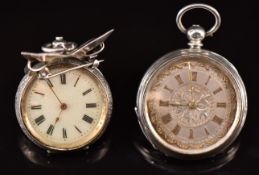Two silver pocket watches each with gold hands, Roman numerals, ornately decorated dial and engraved