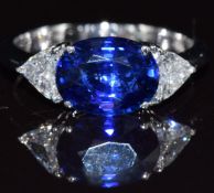 An 18ct white gold ring set with a sapphire of approximately 1.7ct and trillion cut diamonds, each