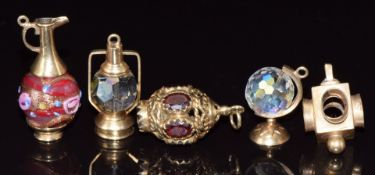 Five 9ct gold charms, three in the form of lanterns, one set with garnets, one a globe and the other