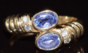 A 14k gold ring set with two oval cut tanzanites, each approximately 0.4ct and four diamonds, 4.