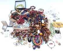A collection of costume jewellery including wooden beads, brooches, earrings, etc