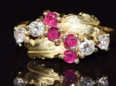An 18ct gold ring set with diamonds and rubies in a foliate setting, 3.1g, size M