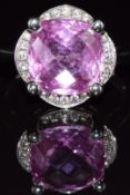 An 18ct white gold ring set with a pink sapphire surrounded by diamonds, 6.7g, size M