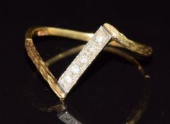 An 18ct gold ring set with diamonds in a V with textured shoulders, 1.6g, size O