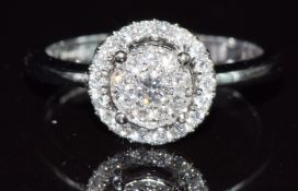 An 18ct white gold ring set with diamonds in a halo cluster, total diamond weight approximately 0.