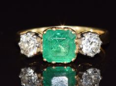 An 18ct gold ring set with an emerald cut emerald of approximately 1.8ct and two old cut diamonds