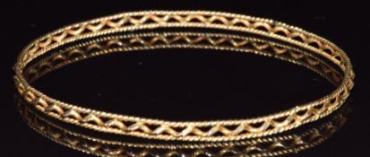 A yellow metal bangle with wavy decoration, 6.8g