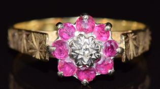 An 18ct gold ring with a diamond surrounded by rubies, 4.4g, size R