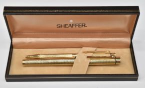 Boxed Sheaffer White Dot fountain pen and ballpoint pen set, both with gold plated knurled bodies,