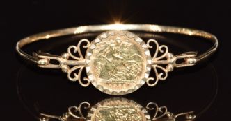 A 9ct gold bangle set with a 1982 gold half sovereign, 10g, 6 x 5.2cm