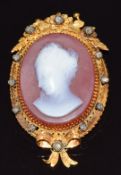 Victorian yellow metal brooch set with an agate cameo of a young woman, within a foliate border