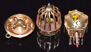 A French 18ct gold roulette spinning charm (2.3g), a 9ct gold cuckoo clock charm set with enamel and