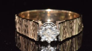 A 9ct gold ring set with a diamond with textured shoulders, 3.2g, size N