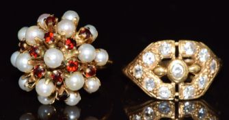 A yellow metal ring marked 21k (3.8g, size O) and a yellow metal ring set with pearls and garnets,