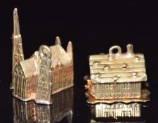 A 14ct gold charm in the form a chalet opening to reveal a person in bed with detailed window,