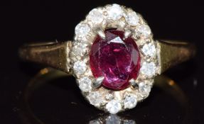 An 18ct gold ring set with an oval cut ruby surrounded by diamonds in a platinum setting, 3g, size