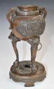 Chinese bronze twin handled censer raised on three stylised figural legs and with cast decoration,